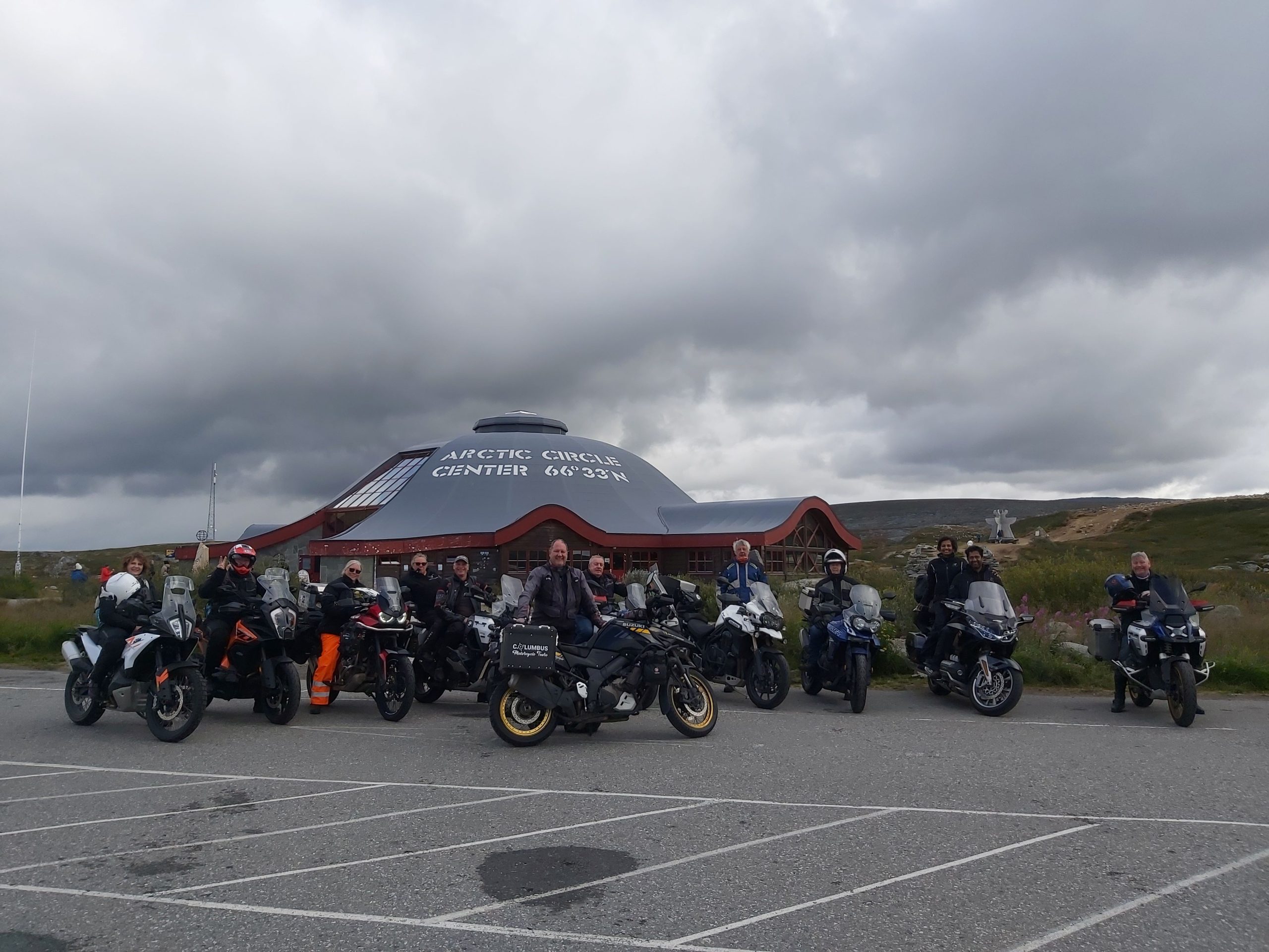 Motorcycles at Arctic Circle Centre Norway riders celebrating crossing Arctic Circle landmark achievement certificate Norwegian motorcycle tour