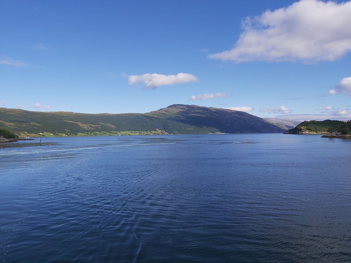 Ferry crossing Norwegian fjord coastal highway clear blue skies best day tour