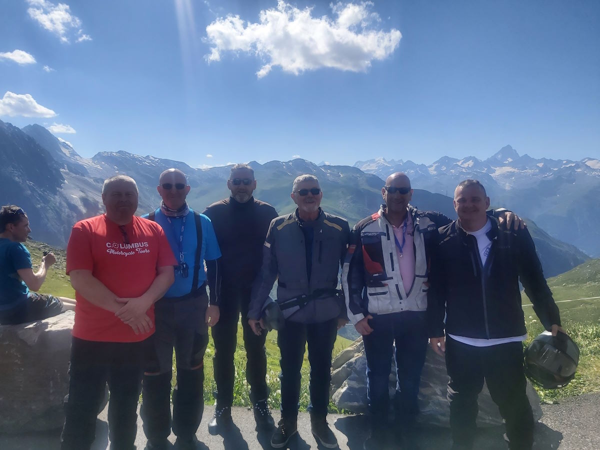 Swiss mountain Nufenen Pass hairpin bends Alpine meadows Columbus motorcycle group photo stop